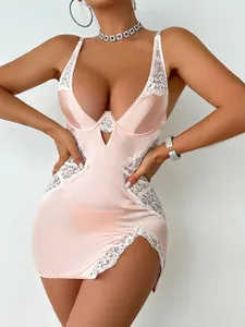 Détail d'une nuisette en satin rose avec dentelle blanche et fente latérale
