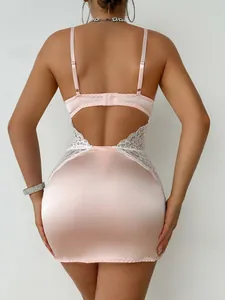 Détail de la robe rose en satin dos nu avec broderie en dentelle blanche élégante