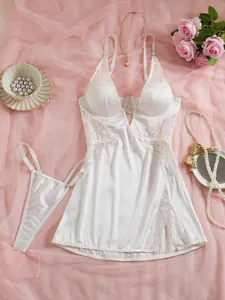 Ensemble lingerie en dentelle et satin blanc avec nuisette fendue et string sur fond résille rose