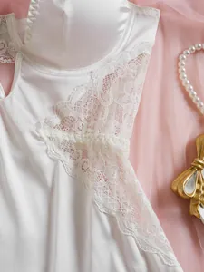 Détail de lingerie en satin blanc avec dentelle exquise sur fond en tulle rose