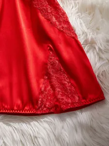 Détail d'une chemise de nuit en satin rouge avec dentelle fine et fente latérale élégante