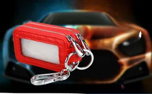 Detail view of red lychee grain leather car key case with double zippers and clear window