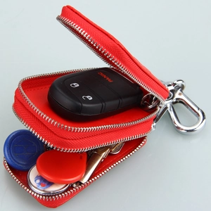 Detail view of red double-zipper leather car key case with dual storage and metal hook