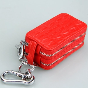 Detail of red crocodile texture leather car key bag with double zippers and silver carabiner