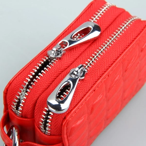 Macro view of red checkered genuine leather car key bag with dual silver zippers