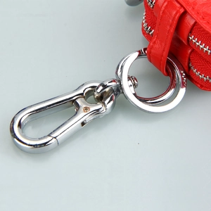 Macro shot of red pebble leather car key case with dual zippers and silver spring hook
