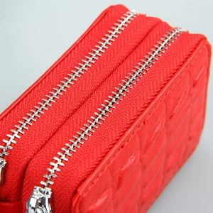 Detail of red genuine leather car key case with double zippers and diamond texture