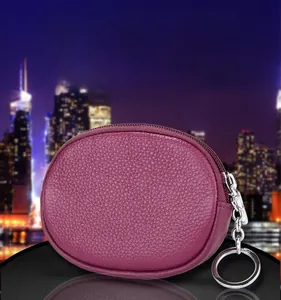 Detail of a dark purple litchi grain leather mini coin purse with silver key ring