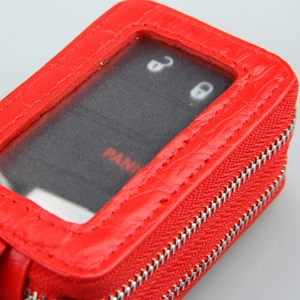 Macro shot of red crocodile embossed leather key case with double zipper and clear window