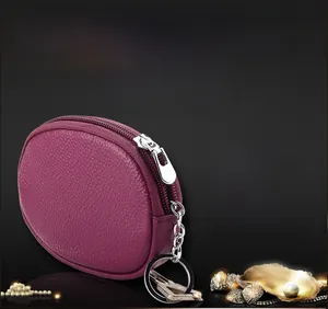 Close-up of a purple pebble grain leather mini coin purse with silver key ring and zipper