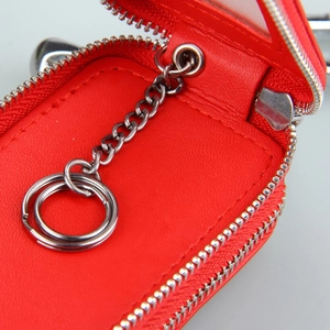 Detail view of red leather car key pouch interior with silver chain and dual rings