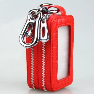 Detail view of red pebble leather car key case with double zippers and clear window