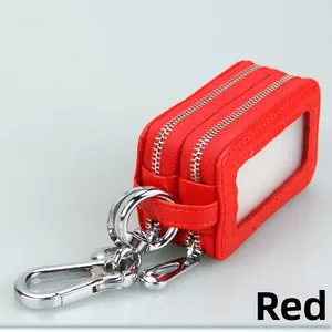 Detail view of red leather car key case with dual zippers and transparent side window