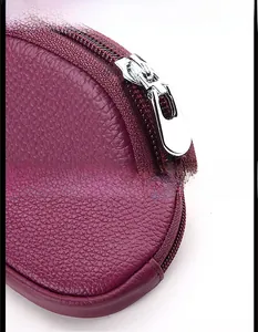 Detail of purple lychee grain leather mini purse with metal zipper and strap buckle