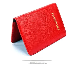 Détail du protège-passeport en cuir rouge avec inscription dorée et texture grainée