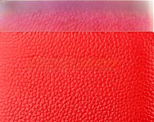 Gros plan du protège-passeport en cuir rouge grainé avec gaufrage doré élégant