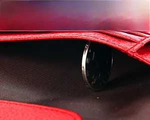 Détail du porte-passeport en cuir rouge montrant le compartiment monnaie et la doublure