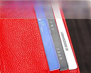 Détail du protège-passeport en cuir rouge avec fentes pour cartes et texture grainée