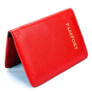 Protège-passeport en cuir grainé rouge avec inscription dorée sur fond blanc