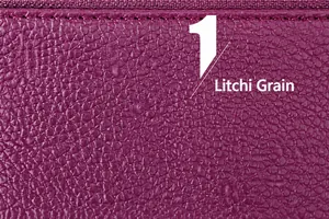 Close-up of purple lychee grain leather texture with premium stitched zipper detail