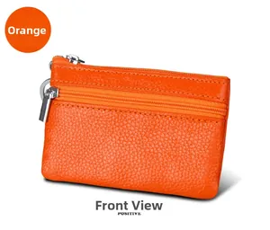 Detail of orange pebble grain leather coin purse with double silver zippers and key ring
