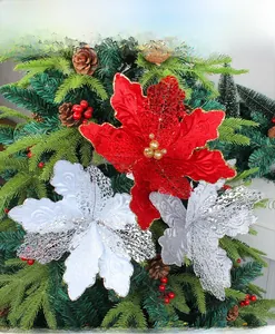 Détail de fleurs de Noël ajourées à paillettes rouges et argentées sur sapin