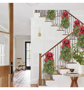 Detail van kerstslingers voor trappen met rode strikken en gouden ornamenten