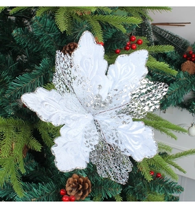 Fleur de Noël blanche à paillettes et maille argentée creuse sur un sapin de Noël