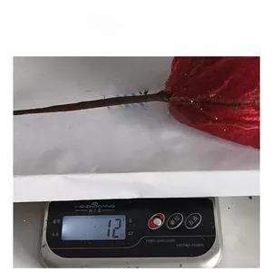 Weight detail of decorative red mesh Christmas flower showing 12g on a scale