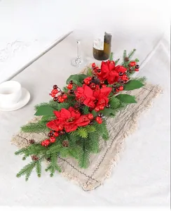 Close-up of Christmas table garland with red poinsettias, pine needles and pine cones