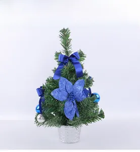 Détail d'un mini sapin de Noël artificiel avec nœuds bleus et ornements argentés