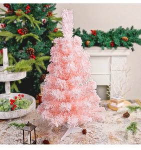 Close-up of a small pink flocked Christmas tree with realistic snow effect for home decor