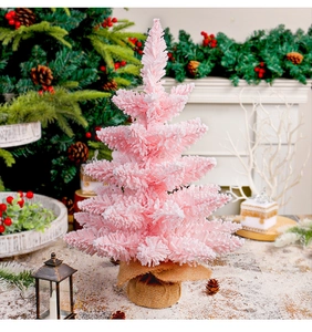 Close-up of pink Christmas tree with snow flocking and burlap base for festive decor