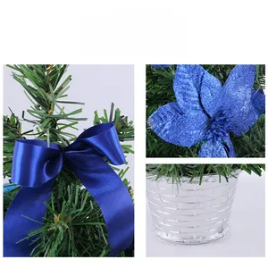 Détails d'un mini sapin de Noël avec poinsettia bleu et base argentée texturée