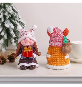 Detail von Weihnachts-Zwergfiguren aus Harz mit roten Strickmützen und Geschenkboxen