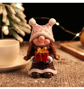 Detail einer Weihnachts-Gnom-Figur aus Harz mit Geschenkschachtel und Bommelmütze
