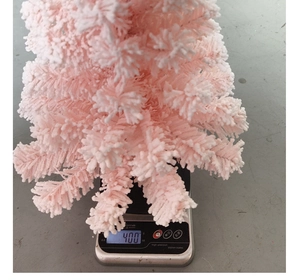 Pink flocked Christmas tree desktop decoration showing a 400g weight measurement on a scale