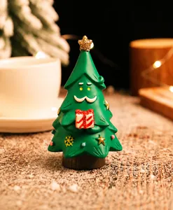 Dettaglio di una statuetta creativa ad albero di Natale in resina con pacco regalo