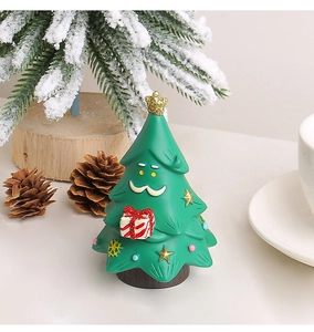 Macro di una statuetta di albero di Natale in resina con scatola regalo sulla scrivania
