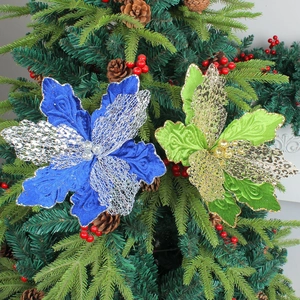 Fleurs de Noël pailletées bleues et vertes avec pétales en résille sur une branche de sapin