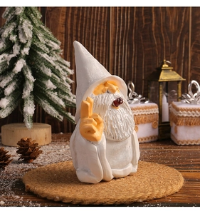 Détail de nain de jardin en résine avec barbe blanche et pipe sur tapis de Noël