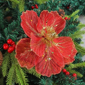 Sparkling red mesh Christmas flower with gold sequins on green pine branches