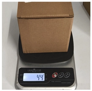 Detailed view of the 44g Christmas gnome figurine in a brown corrugated packaging box