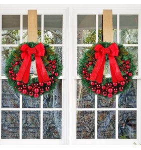 Detailed view of artificial Christmas wreaths with red berries and large velvet bows