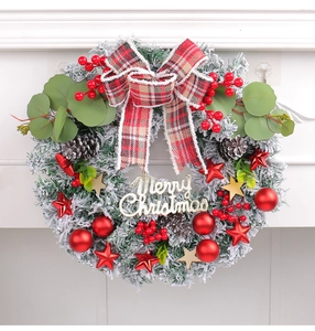 Close-up of Christmas wreath with red berries, pine cones and Merry Christmas sign