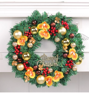 Close-up of Christmas wreath with red berries, gold baubles and Merry Christmas sign