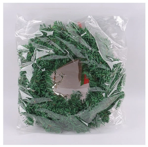 Detailed view of a Christmas pine wreath with silver reindeer and striped ribbon in clear bag