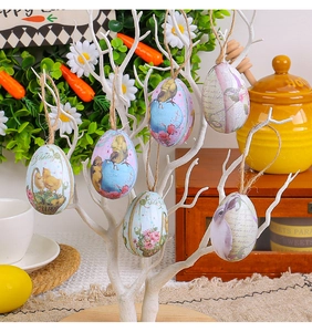 Gros plan d'oeufs de Pâques peints avec motifs floraux suspendus à des branches par cordes