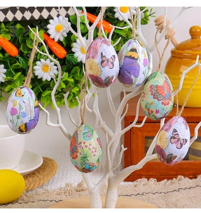 Gros plan d'oeufs de Pâques suspendus vintage avec motifs floraux sur branches blanches