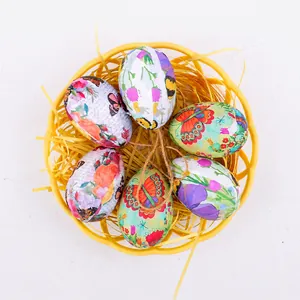 Détail d'œufs de Pâques peints à la main avec motifs papillons dans un panier tressé